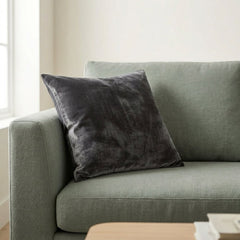 Gray cushion on a green sofa in a living room setting